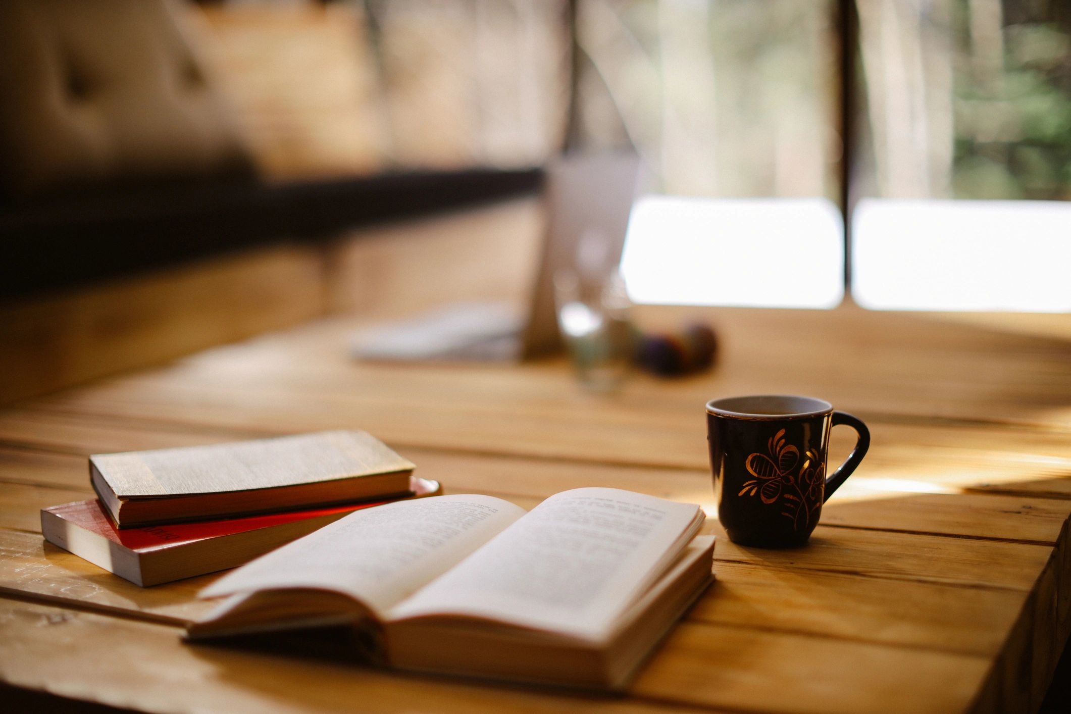Stack of books and a warm cup of coffee on a table