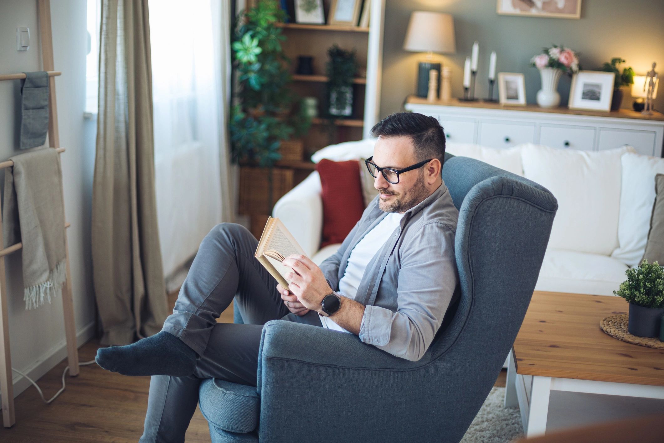 Person reading a book in a cozy living room